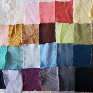 May include: A collection of 25 fabric swatches in various colors, including pink, red, yellow, green, blue, brown, purple, and gray. The swatches are arranged in a grid pattern on a white surface.