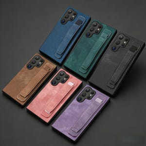 May include: A collection of leather phone cases in various colors, including blue, green, brown, pink, black, and purple. Each case features a camera cutout and a hand strap for secure grip. The cases are designed for a smartphone.