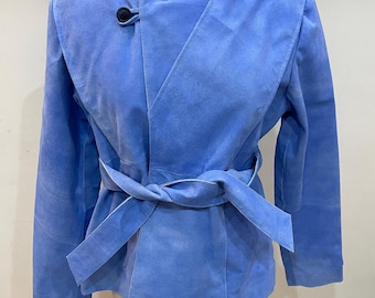 Peut inclure: Veste en daim bleu clair avec un design enveloppant et une ceinture assortie. La veste a un col montant et une fermeture à bouton noir unique. Les manches sont longues, et la veste est présentée sur un mannequin.
