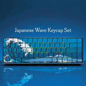 May include: A keyboard with a Japanese wave design keycap set. The keycaps are a gradient of blue and green, with a wave and mountain scene. The text "Japanese Wave Keycap Set" is above the keyboard.