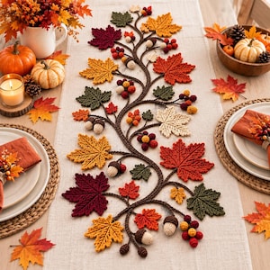 Può includere: Un runner da tavola in tessuto beige caratterizzato da un intricato design centrale all'uncinetto con foglie d'acero autunnali nei toni del rosso, arancione, giallo e verde, intervallate da piccole ghiande e grappoli di bacche.