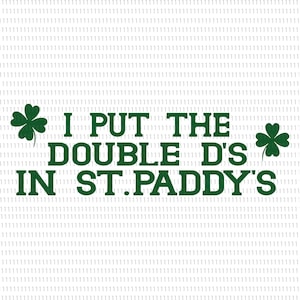 May include: White background with the text "I PUT THE DOUBLE D'S IN ST.PADDY'S" in dark green. The text is accompanied by two green shamrock clovers, one on each side of the text. The design is for St. Patrick's Day.
