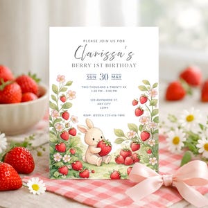 Puede incluir: Una invitación de cumpleaños con una ilustración en acuarela de un conejito sosteniendo una fresa, rodeado de fresas y flores. El texto de la invitación dice "Clarissa's Berry 1st Birthday" con detalles de fecha y hora. El diseño está sobre un fondo blanco.