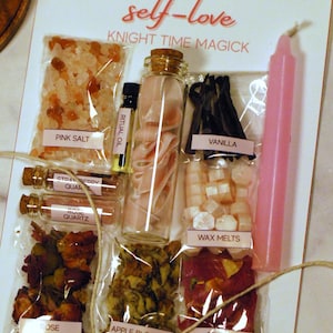 May include: A DIY Spell Jar Kit for self-love, featuring pink salt, ritual oil, rose quartz, vanilla, wax melts, rose petals, apple blossom, and a pink candle. The kit includes a glass jar with pink ribbon and is tied with twine.