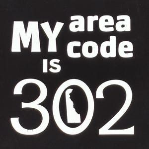 May include: Black graphic with the text "MY area code IS 302". The number 302 includes a white outline of the state of Delaware.