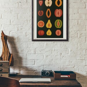 Peut inclure: Une impression encadr&eacute;e pr&eacute;sentant une collection de tranches de fruits color&eacute;es sur fond noir. L'&oelig;uvre d'art pr&eacute;sente divers fruits comme des pommes, des p&ecirc;ches et des agrumes, chacun coup&eacute; pour r&eacute;v&eacute;ler sa structure interne. L'impression est affich&eacute;e sur un mur de briques blanches.