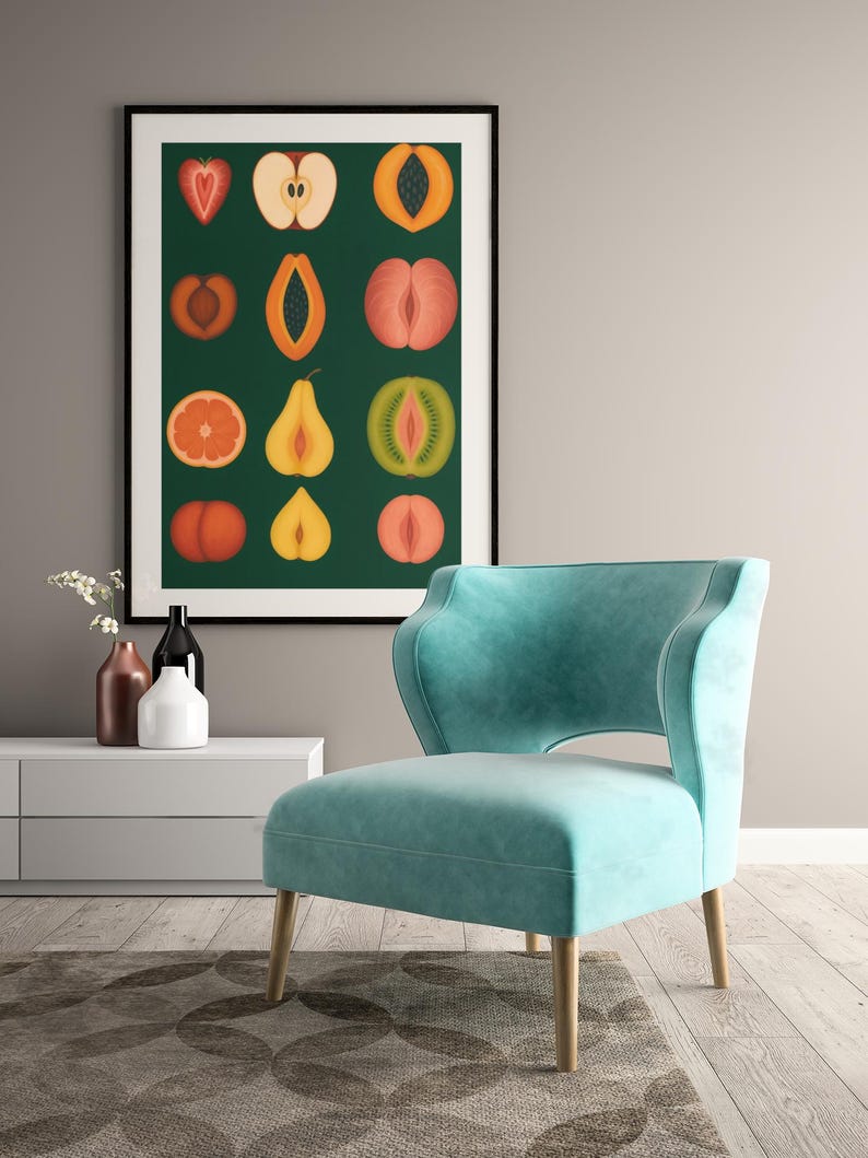 Peut inclure: Une affiche encadr&eacute;e avec des illustrations de fruits coup&eacute;s en tranches, rouges, oranges, jaunes et verts, sur fond vert fonc&eacute;. Un fauteuil bleu sarcelle avec des pieds en bois est devant l'&oelig;uvre. La pi&egrave;ce a une palette de couleurs neutres.