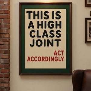 May include: A rectangular framed wall art piece featuring a cream-colored background with bold black text that reads THIS IS A HIGH CLASS JOINT and red text below that reads ACT ACCORDINGLY. The print is enclosed in a dark brown wooden frame.