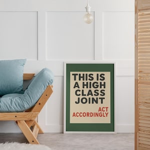 May include: A rectangular framed wall art print featuring a dark green border and a cream-colored center panel. The text reads THIS IS A HIGH CLASS JOINT in bold black letters, with the words ACT ACCORDINGLY printed in red at the bottom.