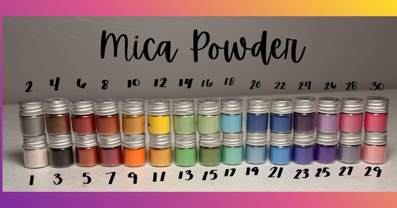May include: A collection of small, clear glass jars filled with various colors of mica powder, arranged in two rows. Each jar has a silver screw-top lid. The text "Mica Powder" is centered above the jars, with numbers 1 through 30 labeled.