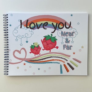 May include: A spiral-bound notebook with a colourful illustration. The cover features a rainbow, two smiling strawberries, and the text "I love you Near & Far." Pastel crayons and stars complete the design.