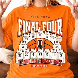 May include: Orange t-shirt with a basketball design. The design includes the text "2026 NCAA FINAL FOUR" and "ILLINOIS MEN'S BASKETBALL". Below the text are basketball jerseys with numbers. The word "INDIANAPOLIS" is at the bottom.