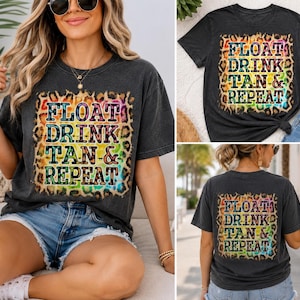 May include: A charcoal grey short-sleeve t-shirt featuring a square graphic with a leopard print border and a rainbow-coloured background. The text "FLOAT DRINK TAN & REPEAT" is printed in bold black letters across the centre of the graphic design.