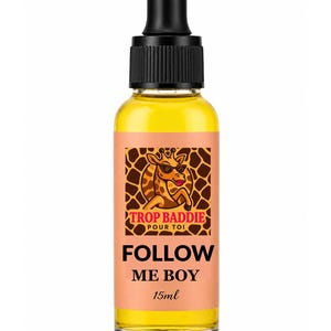 May include: A clear glass bottle with a black dropper top, filled with a yellow liquid. The label features a giraffe wearing sunglasses and the text "TROP BADDIE POUR TOI FOLLOW ME BOY 15ml."