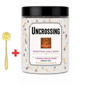 May include: A clear plastic jar with a black lid containing white bath salt mixed with small dried purple and yellow flower petals. The label reads Uncrossing Spiritual Salt Bath, Trop Baddie, and African Juju. A gold-colored metal spoon with a flower-shaped handle is included.