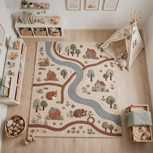 May include: A rectangular area rug featuring a tufted landscape design with a winding blue river, brown paths, green trees, small houses, and various woodland animals including a deer, fox, rabbit, and bear, all set against a cream-colored background.