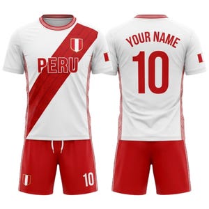 Peut inclure: Un ensemble de maillot et short de football du Pérou, blanc et rouge. Le maillot présente une bande diagonale rouge et le mot "PERU" en rouge. Le short est rouge, avec le numéro "10" sur le short et le maillot.
