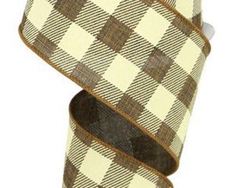 May include: A roll of decorative ribbon with a buffalo plaid pattern in cream and brown. The ribbon is made of a woven material and has a wired edge. The ribbon is ideal for crafting, gift wrapping, and seasonal decor.