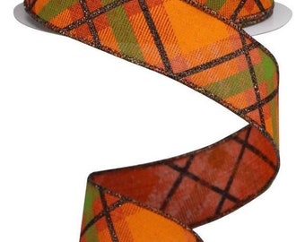 May include: A roll of decorative ribbon with a plaid pattern in orange, green, and brown. The ribbon has a metallic gold trim and is ideal for crafts, gift wrapping, or seasonal decorations.