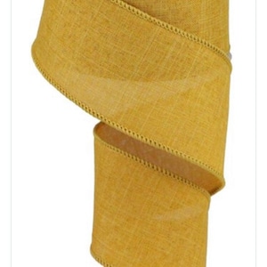 May include: A roll of 2.5 inch wide, mustard yellow, wired ribbon with a burlap texture and a stitched edge.