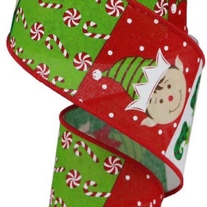 May include: Christmas-themed ribbon on a roll. The ribbon features a green background with candy canes and red and white pinwheels. The edges are red with white polka dots and elf faces. The ribbon is perfect for holiday crafts.