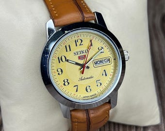 Orologio da polso giapponese vintage Seiko 5 automatico con quadrante giallo e giorno e data, funzionante e ricondizionato.