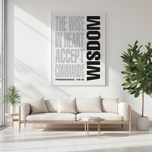 Può includere: Una stampa incorniciata con le parole "THE WISE IN HEART ACCEPT COMMANDS WISDOM PROVERBS 10:8" in bianco e nero. La stampa è appesa sopra un divano color crema con cuscini bianchi. Un piccolo tavolino in legno e una pianta in vaso sono su entrambi i lati del divano.