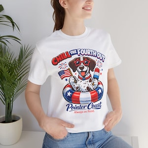 May include: A white t-shirt featuring a graphic of a spotted dog wearing star-shaped sunglasses inside a red, white, and blue striped pool float. The dog holds an American flag and a popsicle. Text reads Chill The Fourth Out Pointer Coast.