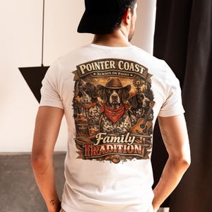 Puede incluir: Camiseta blanca con un gráfico que presenta tres perros, una guitarra y el texto "Pointer Coast Always on Point Family Tradition". El diseño incluye un perro con sombrero de vaquero y pañuelo rojo.