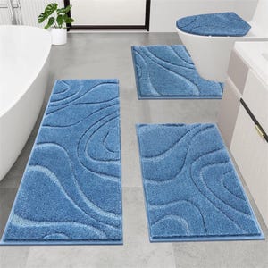 May include: A four-piece bathroom set in a light blue hue. The set includes a rectangular rug, a contour rug, a toilet seat cover, and a long rectangular rug. Each piece features a wavy, textured design.