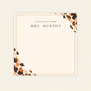 May include: A square stationery note card with a cream background and a thin gold border. The text A LITTLE NOTE FROM MRS. MURPHY is printed in black. The top right and bottom left corners feature watercolor-style brown and tan animal print spots.