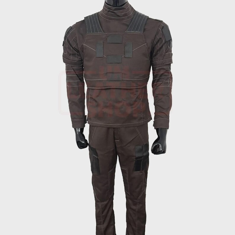 May include: A brown tactical uniform set, including a long-sleeved jacket and pants. The jacket features a high collar, reinforced shoulders, and multiple pockets. The pants have pockets and reinforced knee areas. The uniform is designed for durability and functionality.