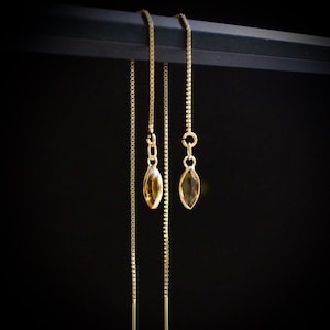 Puede incluir: Tres cadenas de oro con pequeñas piedras preciosas de ámbar en forma de lágrima que cuelgan.