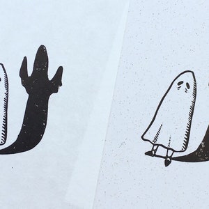 Puede incluir: Dos ilustraciones en blanco y negro de un fantasma con una larga sombra. El fantasma lleva una s&aacute;bana blanca y tiene una peque&ntilde;a cara con dos ojos. La sombra es larga y delgada, con una mano al final.