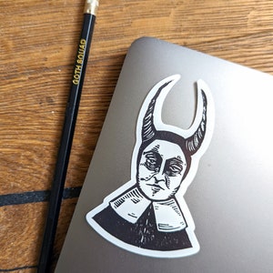 May include: Black and white sticker of a person with horns and a large collar. The person has a serious expression and is looking down.