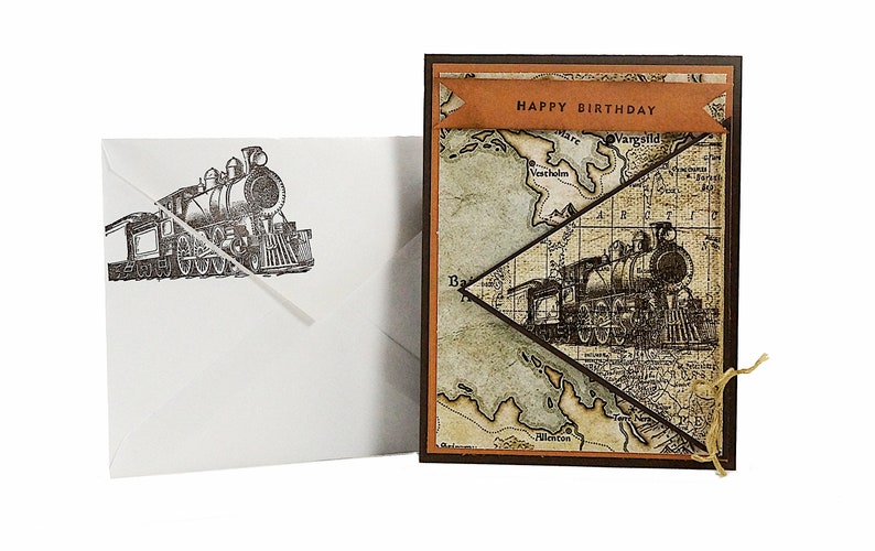 May include: A birthday card with a vintage map design and a steam train illustration. The card features a banner that reads "HAPPY BIRTHDAY". An envelope with a matching train illustration is included.
