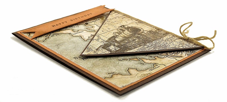 May include: A handmade birthday card with a vintage map design. The card features a brown border and a banner that reads "HAPPY BIRTHDAY". A triangular map overlay is tied with twine.