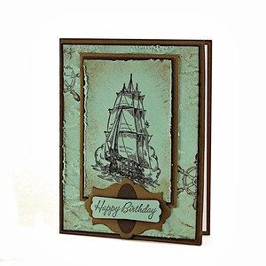 May include: A handmade birthday card with a vintage nautical theme. The card features a black and white illustration of a sailing ship with the words "Happy Birthday" on a brown banner.