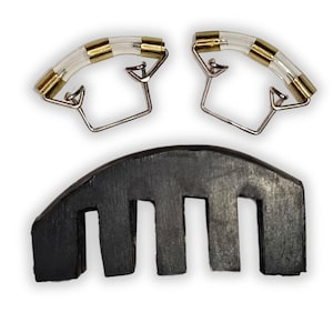 May include: A set of violin accessories, including a black wooden bridge and two clear, curved chin rest clamps with gold-colored accents and silver-colored metal supports. The items are isolated on a white background.