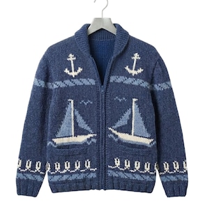 May include: A navy blue zip-up sweater with a nautical theme. The sweater features white sailboat and anchor designs, along with wave and bird patterns. The sweater has two front pockets and a shawl collar.