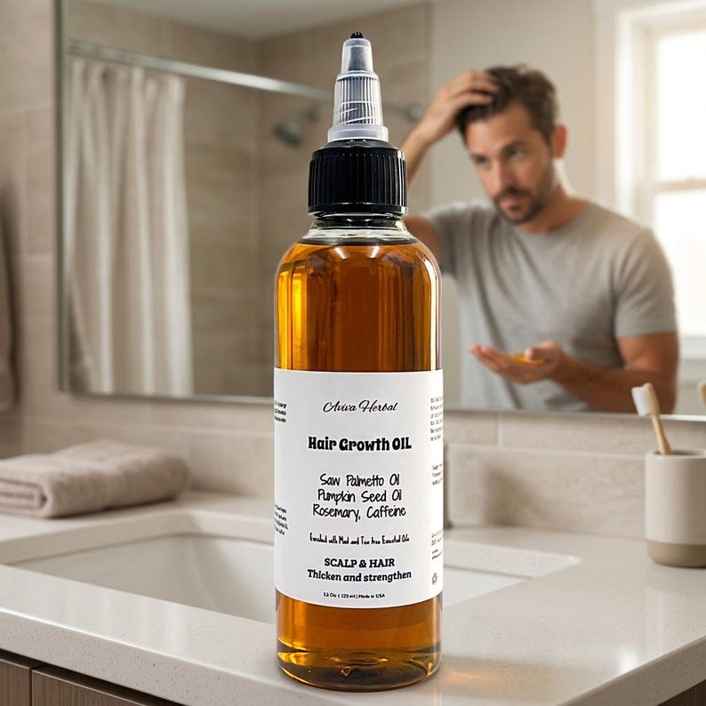 May include: A clear glass bottle of Aura Herbal Hair Growth Oil. The bottle has a black cap and a white label with text. The oil is amber-coloured. The label lists ingredients like Saw Palmetto Oil and Rosemary. The bottle is 118 ml.