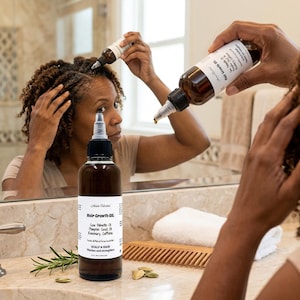 May include: A woman applying hair growth oil in front of a mirror. The brown bottle has a white label with the text "Hair Growth Oil" and ingredients listed. The oil is being applied to the scalp to thicken and strengthen hair.