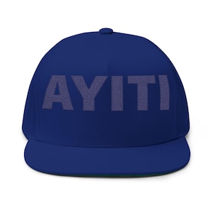 Könnte beinhalten: Eine königsblaue Baseballkappe mit flachem Schirm und dem Wort "AYITI" in einer helleren, strukturierten Schriftfarbe auf der Vorderseite. Die Kappe hat eine abgerundete Krone und einen flachen Schirm. Die Unterseite des Schirms ist grün.