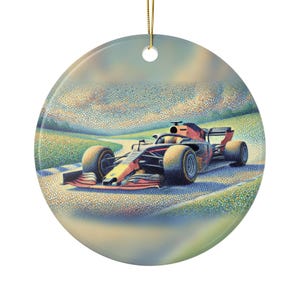 May include: A round ceramic ornament featuring a pointillist-style illustration of a dark blue and orange Formula One race car driving on a track. The background depicts a soft, textured landscape under a cloudy sky, with a gold string at the top.