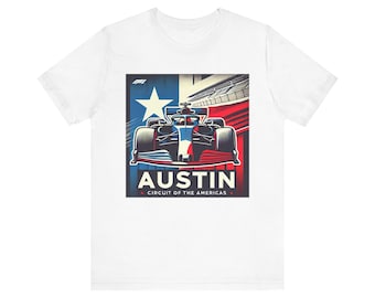 Könnte beinhalten: Ein weißes T-Shirt mit einer Grafik eines Formel-1-Rennwagens, zentriert auf einem Hintergrund mit einem weißen Stern, roten und blauen Streifen sowie dem Text AUSTIN CIRCUIT OF THE AMERICAS und dem F1-Logo oben links.