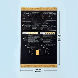 Könnte beinhalten: Schwarzer Gebetsteppich mit goldener Fransen, mit Anleitungsdiagrammen und arabischem Text. Der Teppich ist 165 cm lang und 66 cm breit. Das Design umfasst Illustrationen von Gebetspositionen und zugehörigem Text.
