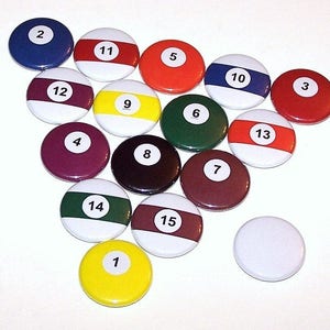 May include: A set of 15 round, colorful, numbered buttons with white numbers. The buttons are arranged in a circle with the number 1 in the center.