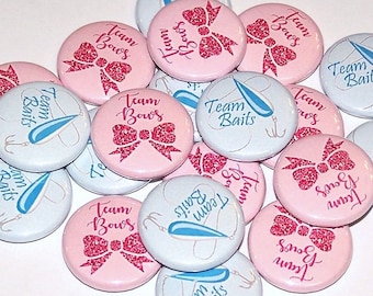 May include: A collection of round pin-back buttons featuring two distinct designs. Some buttons are light pink with a glittery dark pink bow graphic and the text Team Bows. Others are white with a blue fishing lure and the text Team Baits.