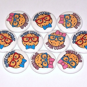 May include: Ten round white buttons with a cartoon cookie wearing glasses and a bow tie. The cookies have red, blue, and pink accents. The text "SMART COOKIE" is printed on each button.