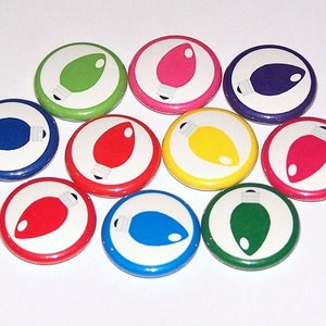 May include: Ten round, colorful buttons with white centers and images of light bulbs. Each button features a different color: red, green, blue, yellow, pink, purple.